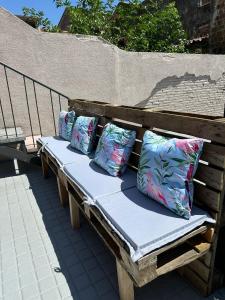 a wooden bench with four pillows on it at Maior 5 Apartamentos in Verín