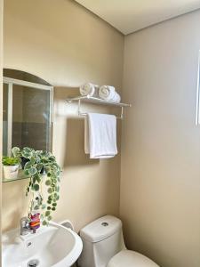 a bathroom with a white toilet and a sink at Iloilo Home Sweet Home in Iloilo City