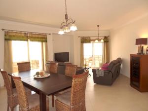 a dining room and living room with a table and chairs at Pera by Check-in Portugal in Armação de Pêra