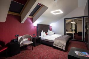 a hotel room with a bed and a chair at The Fifth Floor by Old Town Hotel in Timişoara