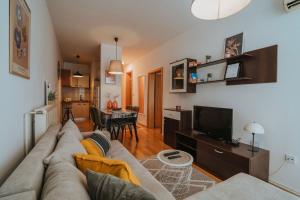 a living room with a couch and a television at Apartman II u centru grada in Kutina