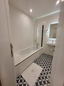 a bathroom with a tub and a toilet and a sink at Carlton Hotel in Sliema