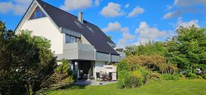 a large white house with a gambrel roof at Käpt'n Gordon, App 2 in Wenningstedt