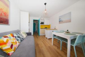 a living room with a couch and a table at La Brise de Donville - A 300m de la plage in Donville-les-Bains