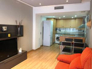 a living room with a couch and a kitchen at Apartament L'Ampolla MONICA a 50m del mar amb parking in L'Ampolla
