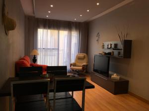a living room with a couch and a television at Apartament L'Ampolla MONICA a 50m del mar amb parking in L'Ampolla