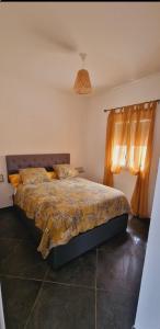 una camera da letto con un letto con un piumone e una finestra di Maison Vacance Proche De Calvi a Calenzana
