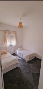 una camera con due letti e una luce a ciondolo di Maison Vacance Proche De Calvi a Calenzana