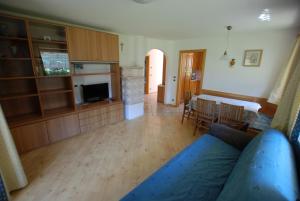 a living room with a couch and a kitchen at Ciasa Rasom in Pozza di Fassa