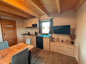 a kitchen with a wooden table and a kitchen with a window at Domek u Ani in Giżycko