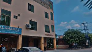 a building with a car parked in front of it at Shelton Hotel Johar Town Lahore in Lahore
