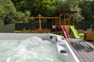 a hot tub with a slide and a playground at IoanaGuestHouse in Turda