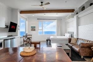 una sala de estar con un sofá y una mesa en Upscale Cliffside Studio with Ocean Views North Bondi, en Sídney