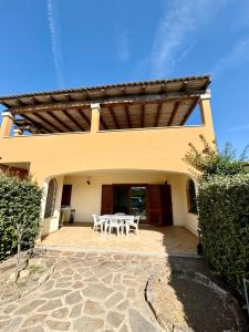 a patio with a table and chairs in front of a house at Case vacanza Corallo - San Teodoro centro in San Teodoro