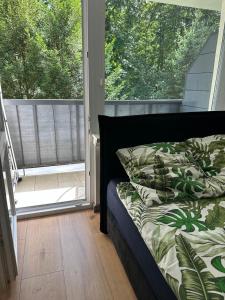 una cama en una habitación con una ventana grande en Apartament 220 na Park Leśny, en Polanica-Zdrój