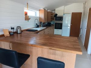 a kitchen with a wooden counter top and a refrigerator at The Steps Holiday Let PHOCLE GREEN ROSS-ON-WYE HR9 7TW in Crow Hill