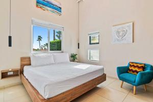 a bedroom with a bed and a blue chair at Caya Mesa Vista 8 Tierra del Sol in Noord +67 photos