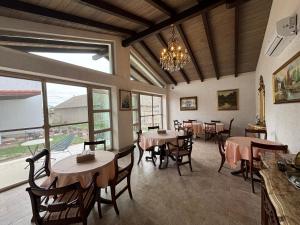 a dining room with tables and chairs and a chandelier at Casa di Antoni in Jurilovca +26 photos