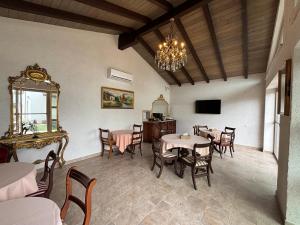 a dining room with tables and chairs and a chandelier at Casa di Antoni in Jurilovca