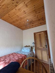 a bedroom with a bed and a wooden ceiling at Tig Rua in Killarney