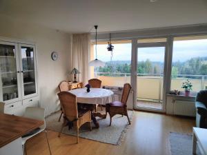 a dining room with a table and chairs and a large window at Apartment Mathilda mit Pool & Sauna in Hohegeiß