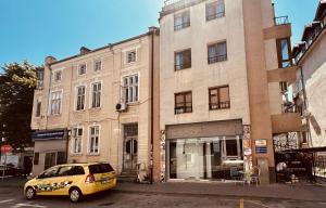 a yellow van parked in front of a building at Swed Cab Embassy HoStel in Varna City