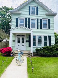 a blue house with a bike parked in the yard at Sweet Escape, 2BR apt in BEACH community, Only 1 hr to NYC! in Norwalk