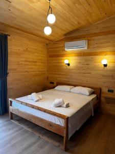 a bedroom with a bed in a wooden room at Cirali Simge Holiday Houses in Cıralı
