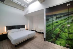 1 dormitorio con 1 cama y una pintura en la pared en Zerupe Hotel, en Zarautz