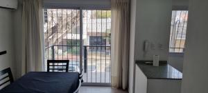 a bedroom with a bed and a large window at Hermoso Departamento En Mendoza in Godoy Cruz