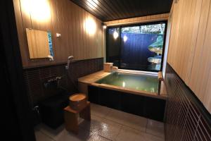 a bathroom with a green tub and a toilet at Yumoto Ueyama Ryokan in Himeji