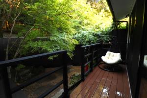 a porch with a swing on a deck with trees at Yumoto Ueyama Ryokan in Himeji