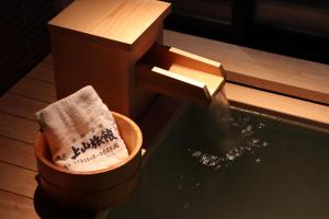 a bucket of water next to a water fountain at Yumoto Ueyama Ryokan in Himeji