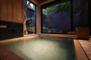 an indoor swimming pool in a house with a large window at Yumoto Ueyama Ryokan in Himeji