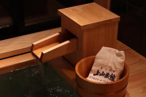 a bucket of water next to a wooden box at Yumoto Ueyama Ryokan in Himeji
