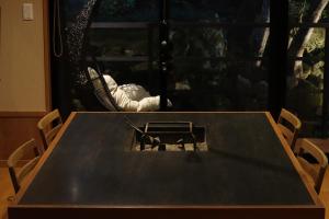 a wooden table with two chairs and a window at Yumoto Ueyama Ryokan in Himeji