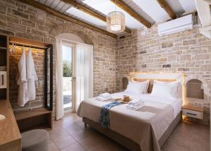 a bedroom with a large bed and a brick wall at Koronio Villas in Kalamaki +108 photos