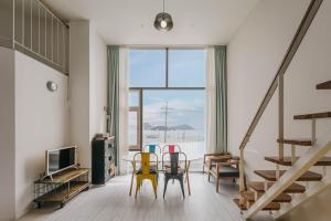a living room with chairs and a table and a television at Greemhouse in Busan