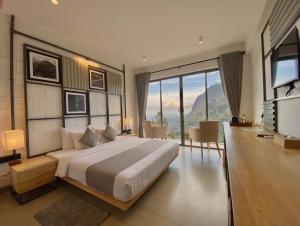 a bedroom with a large bed and a large window at Hotel Onrock in Ella