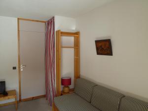 un soggiorno con divano e porta scorrevole di Vamorel, appartement pour 4 au pied des pistes. a Valmorel Altre 3 foto