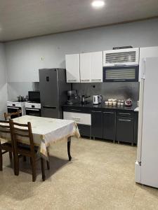 a kitchen with a table with chairs and a refrigerator at Guest House Mariami in Ushkhvanari
