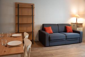 a living room with a blue couch and a table at Terres de France Brest in Brest