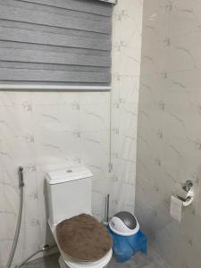 La salle de bains est pourvue de toilettes blanches et d'un siège en bois. dans l'établissement 2 Bedroom Semi- Luxury Apartment in Achimota, à Achimota