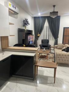 un salon avec une cuisine et un salon avec un canapé dans l'établissement 2 Bedroom Semi- Luxury Apartment in Achimota, à Achimota 4 autres photos