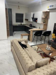 Il comprend un salon avec un grand canapé et une cuisine. dans l'établissement 2 Bedroom Semi- Luxury Apartment in Achimota, à Achimota