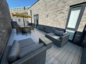 a patio with a couch and chairs and a table at Beautiful Newbuild 5 bedroom Town House in Chelmsford
