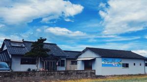 ein weißes Haus mit einem blauen Schild darauf in der Unterkunft stone house in Bungotakada + 15 Fotos