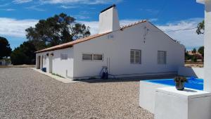 a white building with a swimming pool in front of it at Alentempo in Aldeia de Brescos