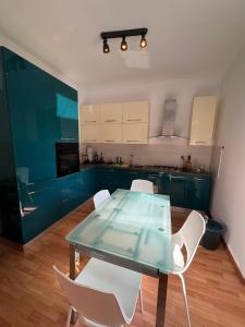 a kitchen with a glass table and white chairs at Casa Giulia in Genoa