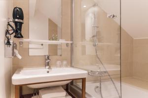 y baño con lavabo y ducha. en Hotel Sixteen Paris Montrouge, en Montrouge